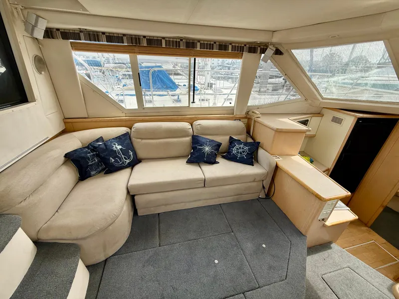 Slide: The Image of 1997 Carver 355 Aft Cabin interior with beige seating and nautical-themed pillows. - 17