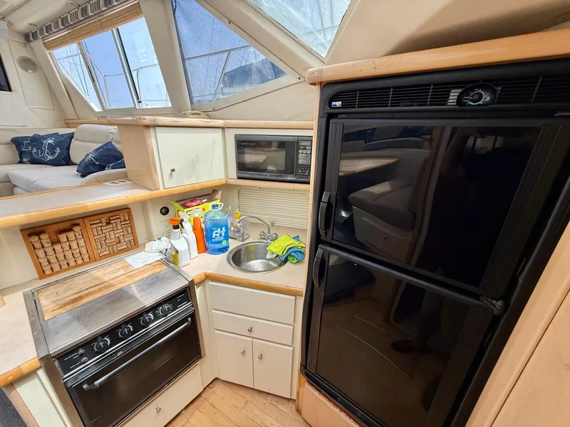 Slide: The Image of 1997 Carver 355 Aft Cabin kitchen with stove, microwave, sink, and refrigerator. - 19