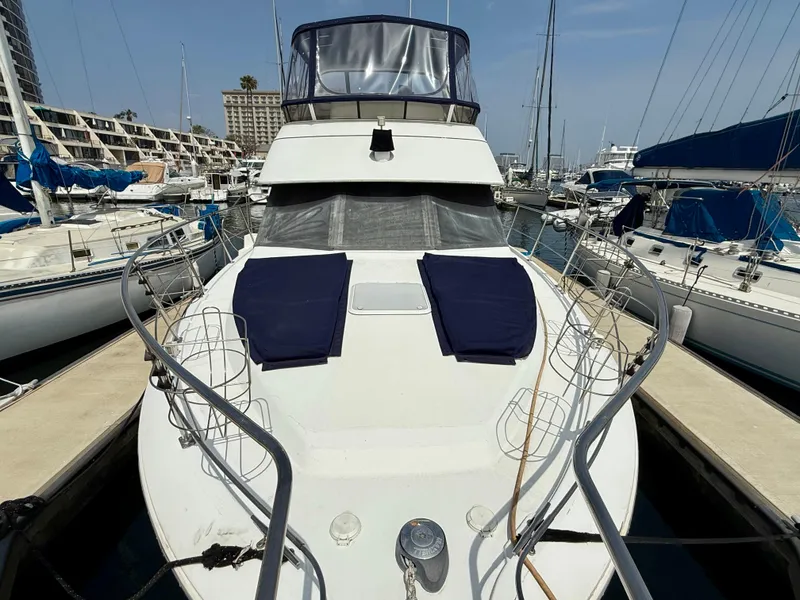 Slide: The Image of 1997 Carver 355 Aft Cabin yacht docked at marina, featuring spacious deck and blue cushions. - 5
