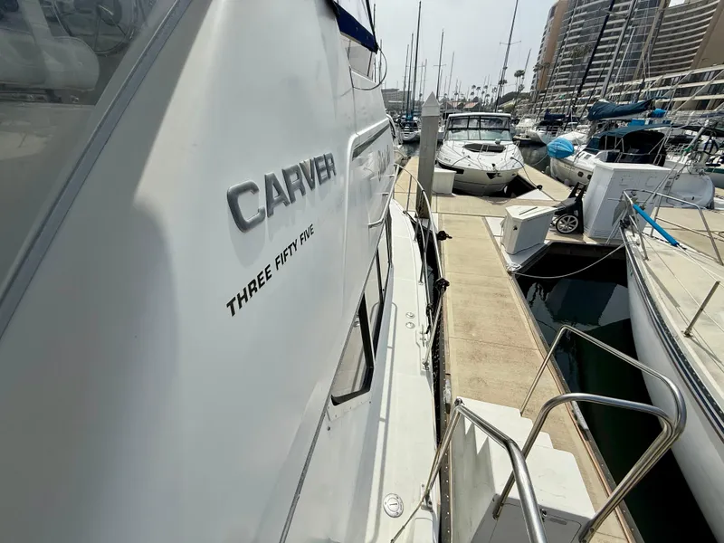 Slide: The Image of 1997 Carver 355 Aft Cabin yacht docked at marina, side view with neighboring boats. - 6