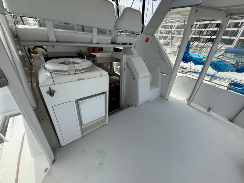 Slide: The Image of 1997 Carver 355 Aft Cabin yacht interior with seating and storage, docked at marina. - 7
