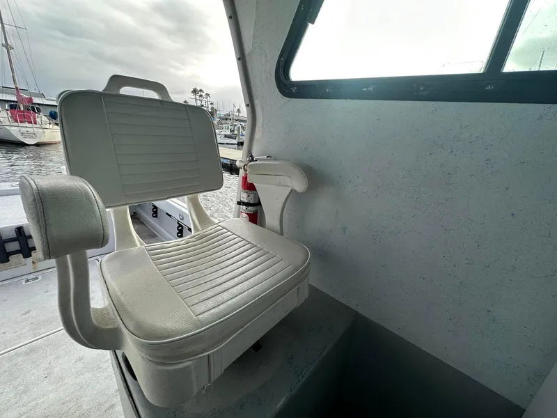 Slide: The Image of Interior of 1987 Radon 26 boat with white seating and window view. - 11