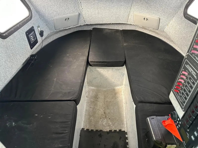 Slide: The Image of Interior cabin of a 1987 Radon 26 boat with black cushions and control panel. - 22