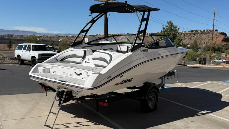 Slide: The Image of 2025 Yamaha AR195 boat on trailer, parked outdoors under clear sky. - 17