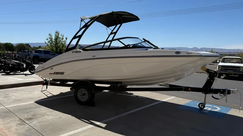 Slide: The Image of 2025 Yamaha Boats AR195 on trailer in parking lot, sunny day. - 19