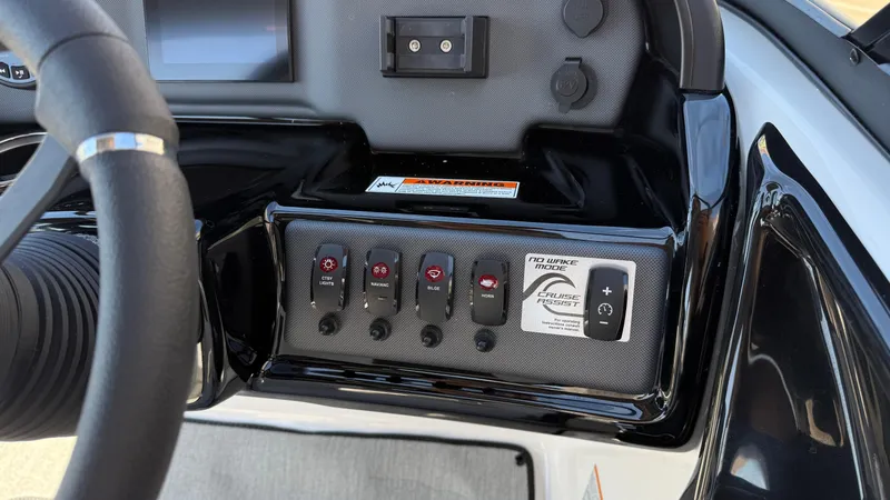 Slide: The Image of Control panel of 2025 Yamaha Boats AR195 featuring various switches and cruise assist. - 38