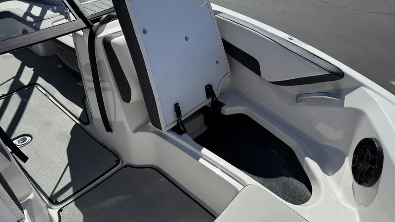 Slide: The Image of 2025 Yamaha Boats AR195 interior storage compartment with open hatch, showcasing sleek design and functionality. - 47