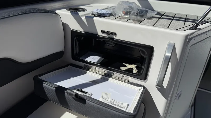 Slide: The Image of 2025 Yamaha AR195 boat interior storage compartment with documents and accessories. - 48