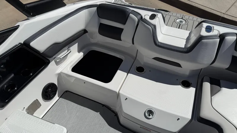 Slide: The Image of 2025 Yamaha AR195 boat interior with seating, cup holders, and storage compartments. - 49