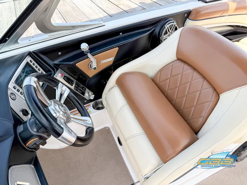 Slide: The Image of 2013 MasterCraft X-45 boat interior with brown and white leather seating and modern dashboard. - 16