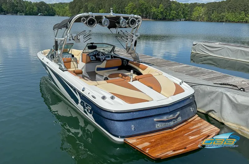 Slide: The Image of 2013 MasterCraft X-45 boat docked on a serene lake. - 2