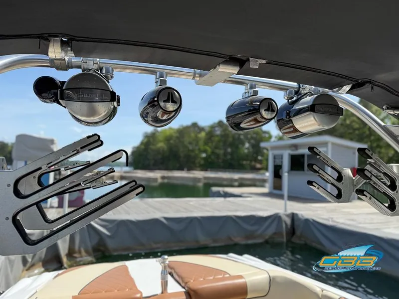 Slide: The Image of 2013 MasterCraft X-45 boat with wakeboard racks and speakers, docked by a serene lake. - 20