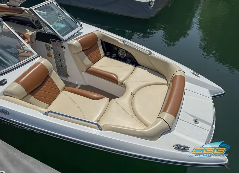 Slide: The Image of 2013 MasterCraft X-45 boat with tan and brown seating, docked on calm water. - 4