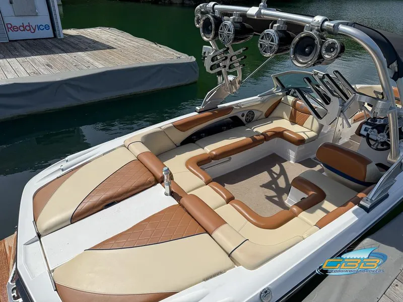 Slide: The Image of 2013 MasterCraft X-45 boat with tan and brown interior, docked near a wooden pier. - 5