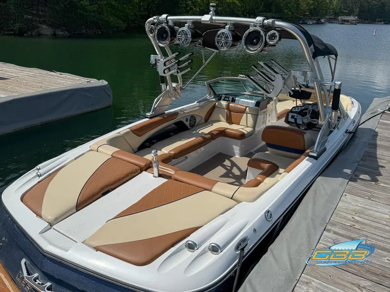 Slide: The Image of 2013 MasterCraft X-45 boat docked on a serene lake, featuring stylish seating and advanced audio system. - 7