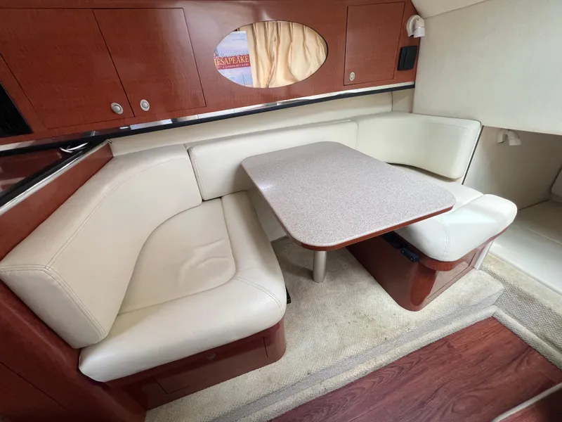 Slide: The Image of 2005 Sea Ray 290 Amberjack cabin interior with cream leather seating and wooden accents. - 16