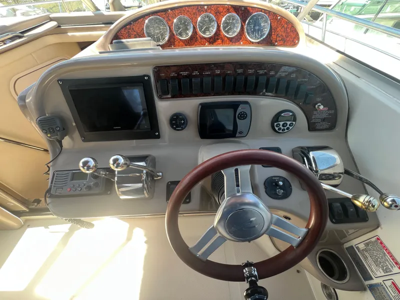 Slide: The Image of 2005 Sea Ray 290 Amberjack helm with steering wheel, gauges, and navigation controls. - 2