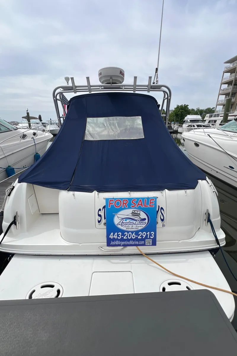 Slide: The Image of 2005 Sea Ray 290 Amberjack boat for sale, docked with blue cover and contact information. - 23