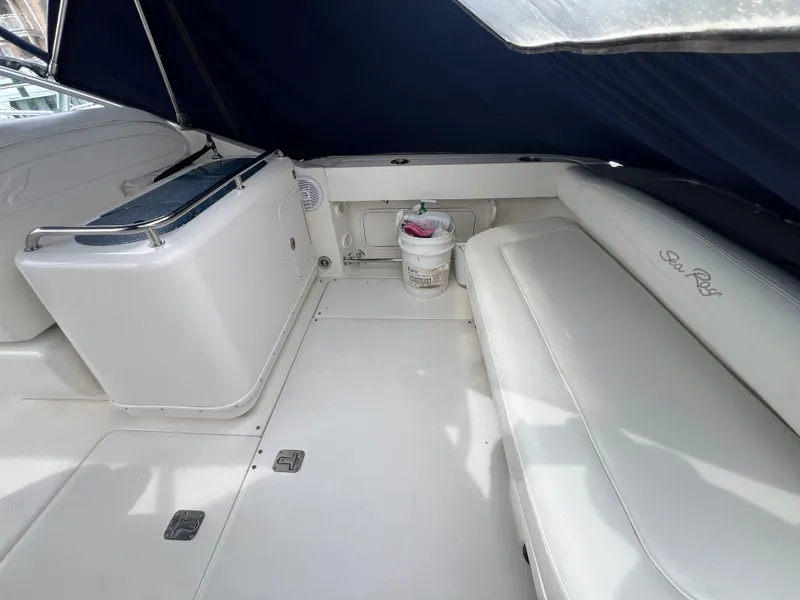 Slide: The Image of 2005 Sea Ray 290 Amberjack boat interior with white seating and storage area. - 5