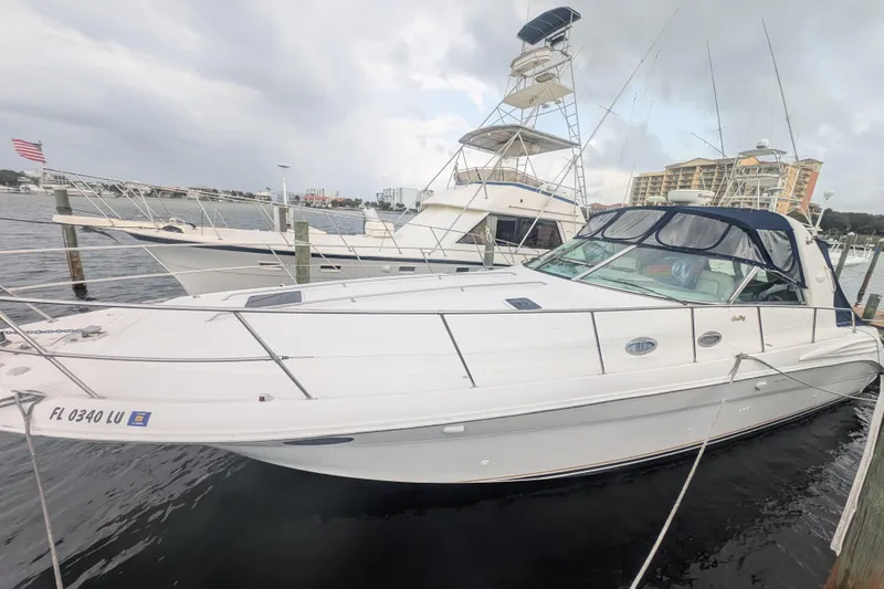 Slide: The Image of 1998 Sea Ray 400 Sundancer yacht docked at marina, overcast sky, nearby boats visible. - 0