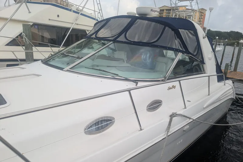 Slide: The Image of 1998 Sea Ray 400 Sundancer yacht docked at marina, featuring sleek design and white exterior. - 1
