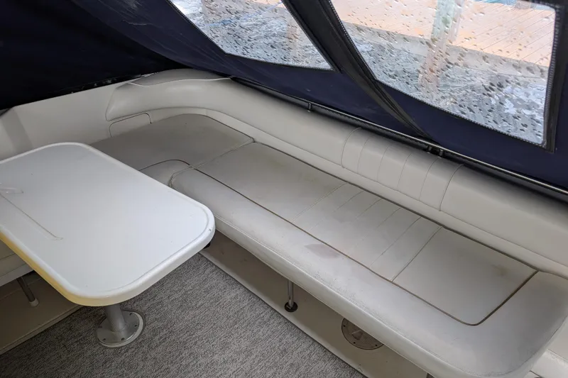 Slide: The Image of 1998 Sea Ray 400 Sundancer interior with white seating and table under a canopy. - 17