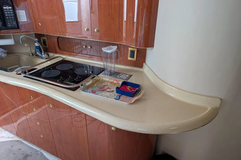 Slide: The Image of 1998 Sea Ray 400 Sundancer kitchen with wooden cabinets and modern appliances. - 27