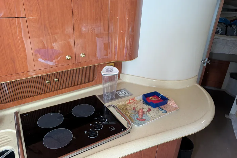 Slide: The Image of 1998 Sea Ray 400 Sundancer kitchen with stove, wooden cabinets, and countertop accessories. - 28