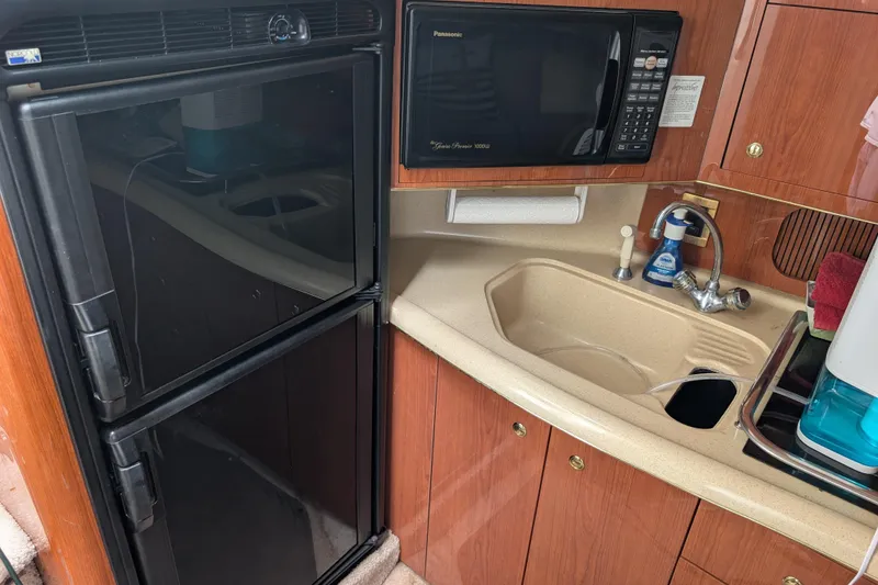 Slide: The Image of 1998 Sea Ray 400 Sundancer kitchen with fridge, microwave, and sink. - 29