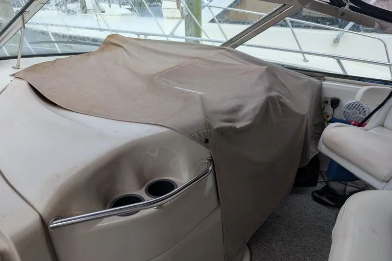 Slide: The Image of 1998 Sea Ray 400 Sundancer cockpit with covered dashboard and seating area. - 30