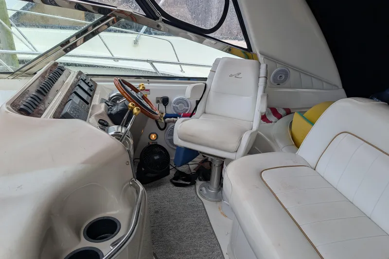 Slide: The Image of Interior of 1998 Sea Ray 400 Sundancer boat with white seating and steering area. - 31