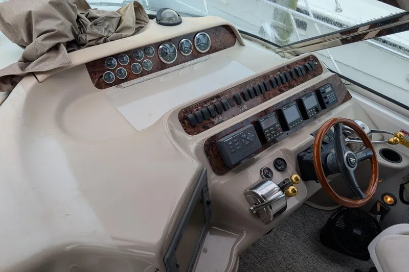 Slide: The Image of 1998 Sea Ray 400 Sundancer helm with gauges, controls, and wooden steering wheel. - 35