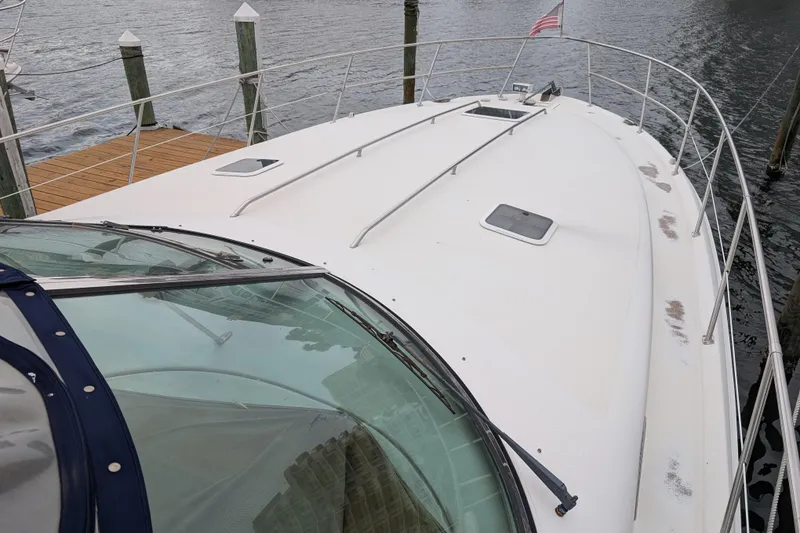 Slide: The Image of 1998 Sea Ray 400 Sundancer yacht docked, showcasing sleek deck design and railing. - 9