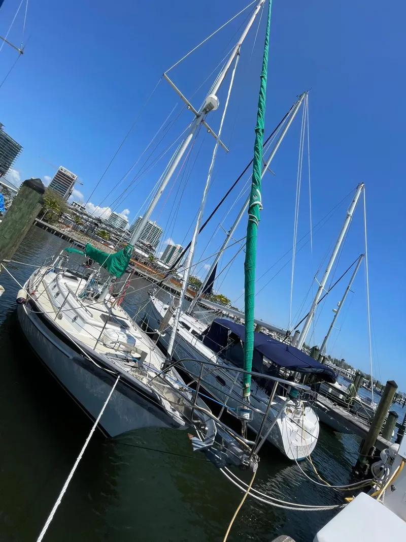 The Image of 1986 Cabo Rico CB38 sailboat docked in marina under clear blue sky. - 0