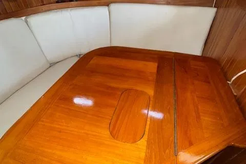 Slide: The Image of 1986 Cabo Rico CB38 interior with polished wooden table and cushioned seating. - 12