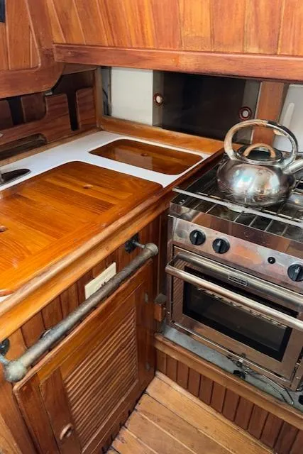 Slide: The Image of 1986 Cabo Rico CB38 yacht kitchen with wooden cabinetry and stainless steel stove. - 17