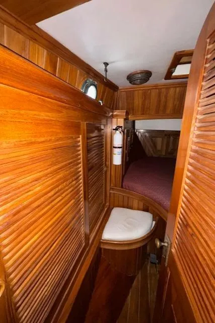 Slide: The Image of 1986 Cabo Rico CB38 yacht interior with wooden paneling and cozy sleeping area. - 22