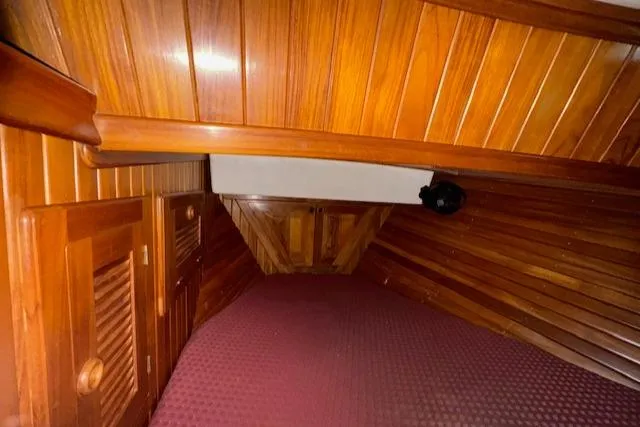 Slide: The Image of Interior cabin of 1986 Cabo Rico CB38 sailboat with wooden paneling and maroon bedding. - 23