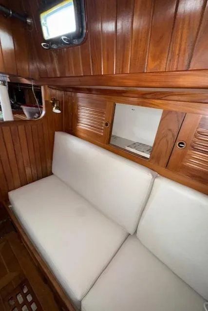 Slide: The Image of 1986 Cabo Rico CB38 yacht interior with wooden paneling and white cushioned seating. - 27