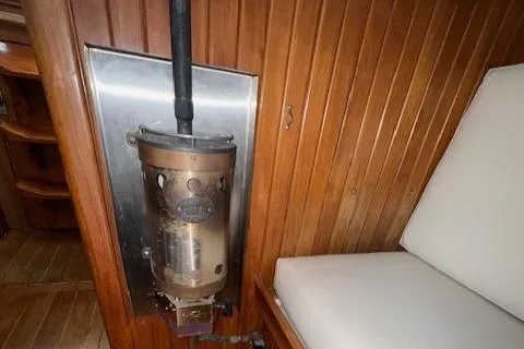Slide: The Image of Vintage Cabo Rico CB38 cabin interior with wood paneling and a metal heater, 1986 model. - 28
