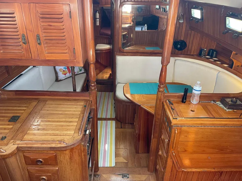Slide: The Image of 1986 Cabo Rico CB38 yacht interior with wooden cabinetry and cozy seating area. - 7