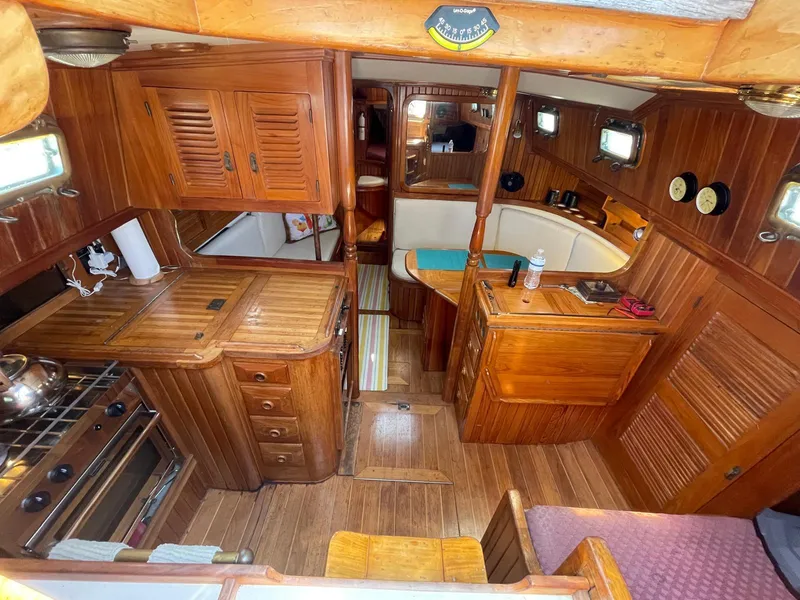 Slide: The Image of Interior of 1986 Cabo Rico CB38 sailboat with wooden cabinetry and compact kitchen. - 8