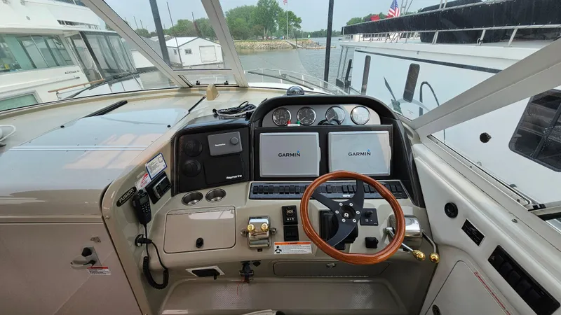 Slide: The Image of 2007 Sea Ray 40 Motor Yacht helm with Garmin navigation, wood steering wheel, and control panel. - 10