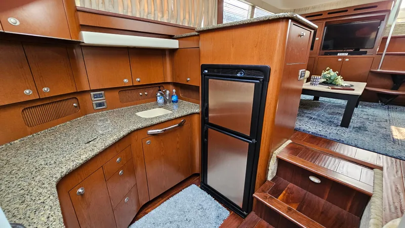 Slide: The Image of 2007 Sea Ray 40 Motor Yacht interior with kitchen, fridge, and dining area. - 16