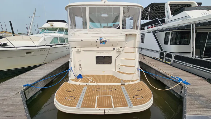 Slide: The Image of 2007 Sea Ray 40 Motor Yacht docked, rear view with wooden deck and marina surroundings. - 5