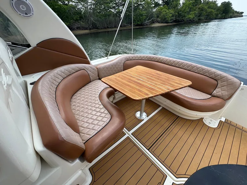 Slide: The Image of Luxurious seating area on 2003 Sea Ray 340 Sundancer yacht with wooden table and water view. - 10