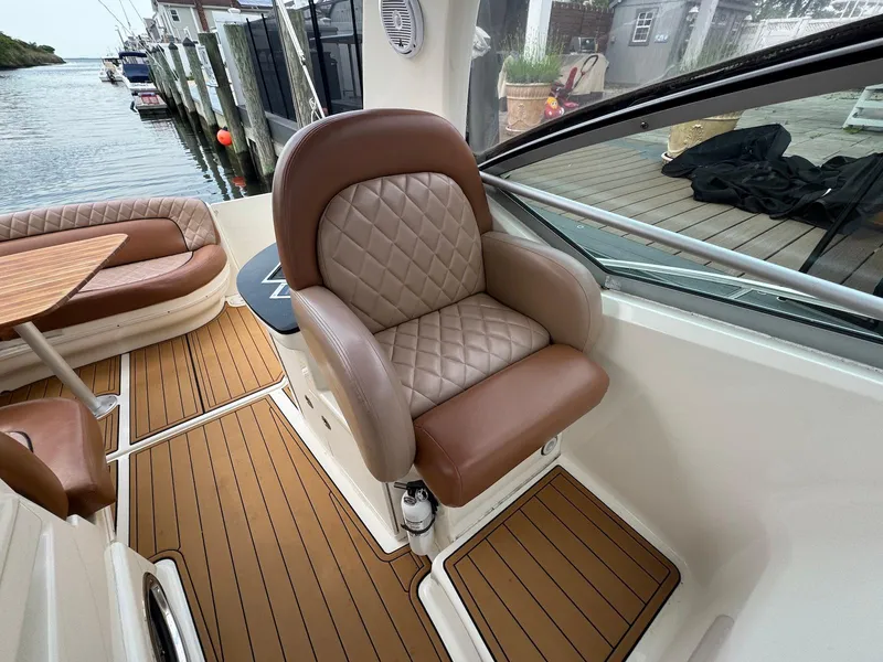 Slide: The Image of 2003 Sea Ray 340 Sundancer cockpit with luxurious seating and wood-style flooring. - 11