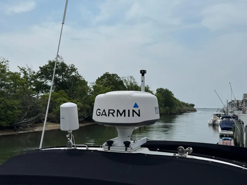 Slide: The Image of 2003 Sea Ray 340 Sundancer with Garmin radar, docked near a scenic waterway. - 18