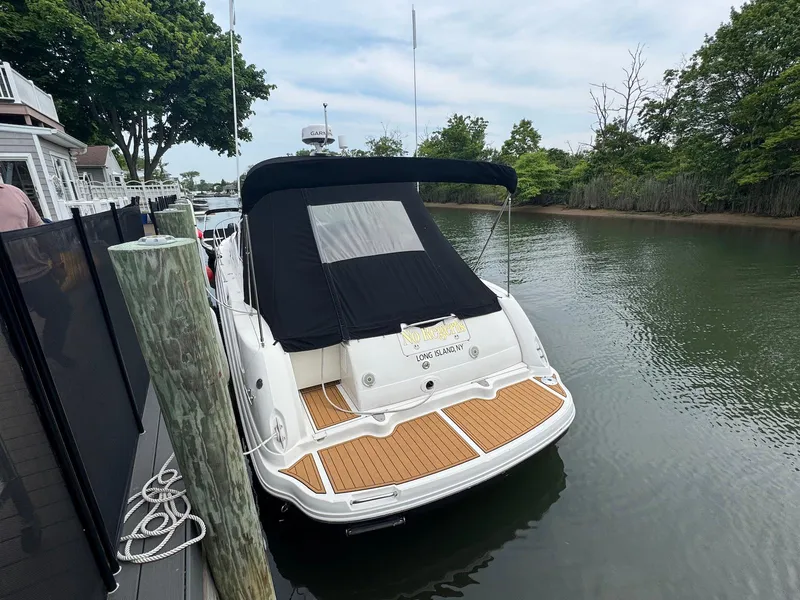 Slide: The Image of 2003 Sea Ray 340 Sundancer docked in a serene canal setting. - 2