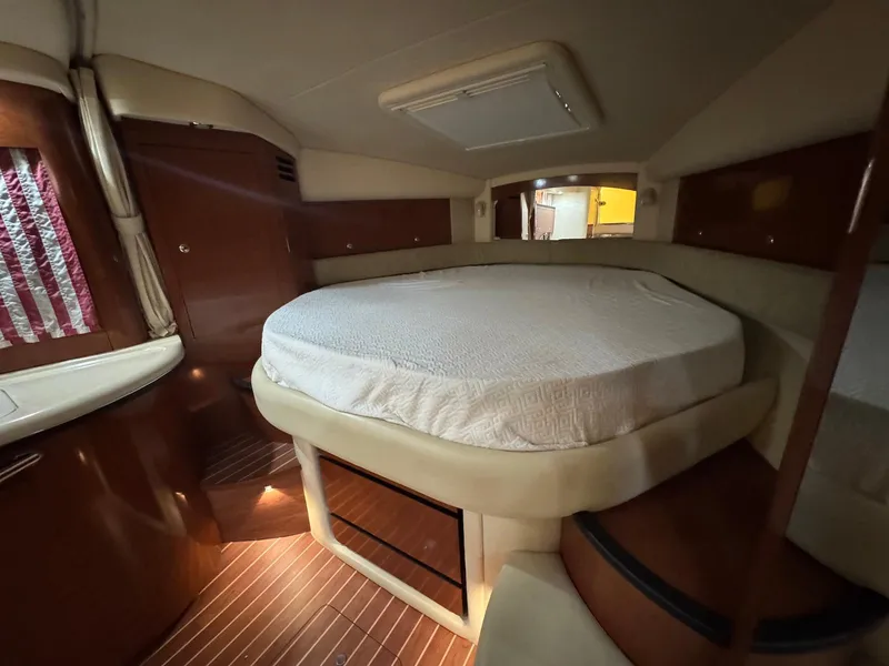 Slide: The Image of 2003 Sea Ray 340 Sundancer cabin interior with bed and wooden accents. - 23